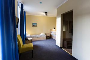 スヴェトロゴルスクにあるVilla Gotlandのホテルルーム ベッド2台&黄色い椅子付