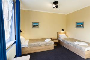 スヴェトロゴルスクにあるVilla Gotlandのベッド2台と窓が備わるホテルルームです。