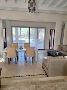 a living room with a couch and a table and chairs at Villa des oliviers in Marrakech