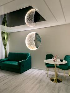 a living room with a green couch and a table at Golden Station Ultraconfort in Iaşi