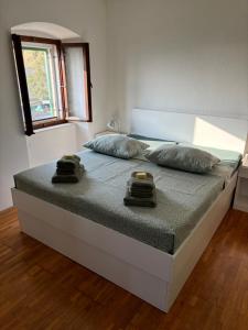 a bed in a bedroom with two towels on it at Kameni cvijet in Murvica
