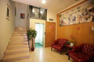 un vestíbulo con una escalera y dos sillas y una escalera en Marconi Rooms, en Cassino