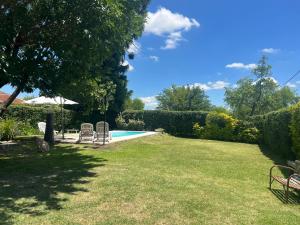 a yard with a swimming pool with two lawn chairs at QUINTA LA ARAUCARIA -Paraná in Paraná