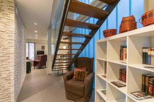 a staircase in a living room with a chair and bookshelves at Casa Soto Del Ebro in Tudela
