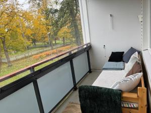balcón con sofá y ventana grande en Modern and spacious apartment with a separate bedroom, en Riihimäki