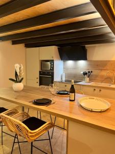 a kitchen with a wooden table with a bottle of wine at Domaine d Arcadie in Montaigu-de-Quercy