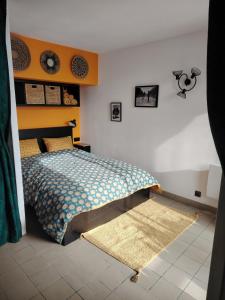 a bedroom with a bed and a rug on the floor at Bel appartement au pied des pistes de serre chevalier in Briançon