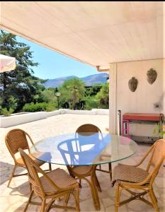 a glass table and chairs on a patio at Casa Giulù- in Palermo