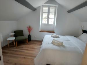 a bedroom with a large white bed and a window at Petite maison centre-ville in Nemours