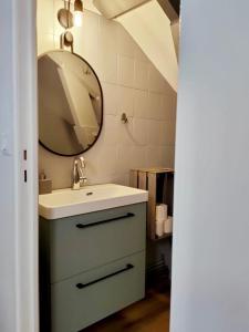 a bathroom with a sink and a mirror at Petite maison centre-ville in Nemours +19 photos