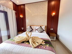 a hotel room with a bed with a towel on it at Sela Cottages in Toyapakeh +13 photos