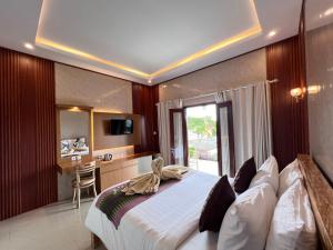 a bedroom with a large bed and a desk in it at Sela Cottages in Toyapakeh