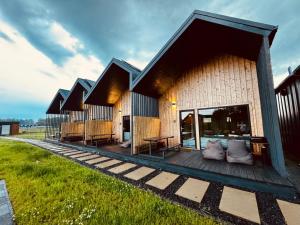 a building with a deck with a table and benches at Sunmare in Sarbinowo