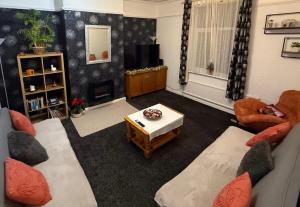 a living room with two couches and a tv at Rotherham Kimberworth in Kimberworth +3 photos