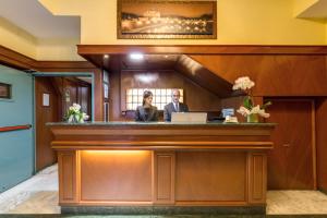 a man and a woman standing at a reception desk at Flower Garden Hotel in Rome