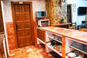 a kitchen with a counter top with a microwave at Casa Rural CerroMoreno in Villarta