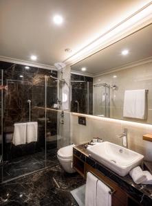 a bathroom with a sink and a shower and a toilet at Sheraton Bishkek in Bishkek