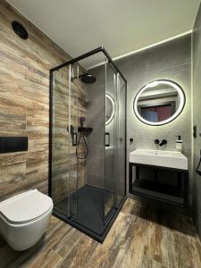 a bathroom with a shower and a toilet and a sink at Nourt Rooms & Kitchen in Karpacz