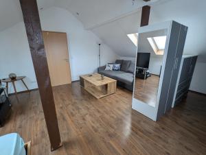 a living room with a couch and a mirror at Dachgeschosswohnung mit Loftcharakter in Sparneck
