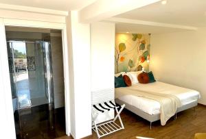 una piccola camera da letto con un letto e una doccia di Villa Greta Hotel Rooms & Suites a Taormina