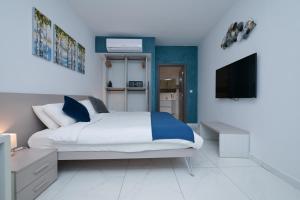 a bedroom with a bed and a flat screen tv at The Exiles Hotel in Sliema +37 photos