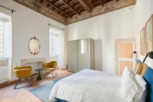 a bedroom with a bed and two chairs at Montevecchio Boutique Apartments in Rome
