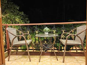 a table and two chairs on a balcony with a table and a plant at Ishaan Holiday Home in Nagaon