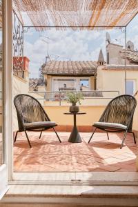 two chairs and a table on a balcony at Montevecchio Boutique Apartments in Rome