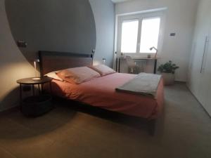 a bedroom with a bed with a table and a window at 4 Piano Apartment in Laveno-Mombello