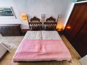 a bedroom with a bed with a pink blanket at Family villa Casa KuKa I wonderful terrace with saltwater pool and BBQ area I beach in walking distance I pets welcome in Fuengirola +27 photos