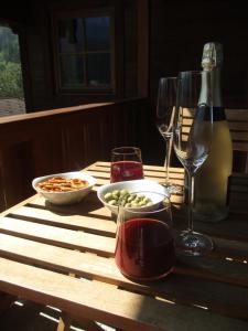 a wooden table with wine glasses and a bowl of food at Villa Alpenoase in Schönau am Königssee