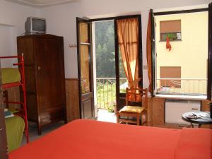 a bedroom with a bed and a window with a balcony at La Miando Rooms in Salza di Pinerolo