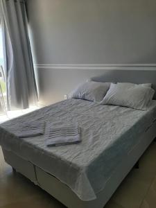 a bed with two towels on it in a bedroom at Casa Linda PÉ Na areia , Cabo Frio in Cabo Frio