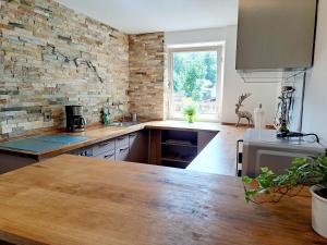 a kitchen with a brick wall and a wooden counter top at Ferienhaus zum Eibsee in Grainau