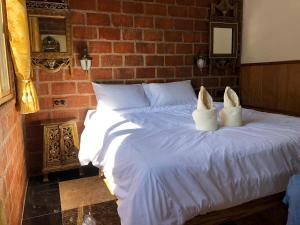 a bedroom with a bed with white shoes on it at Villa Wolfsbau in Pai