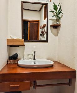 a bathroom sink with a mirror on a wooden counter at พืชไทยเชียงคาน(Plantthai) in Chiang Khan +49 photos