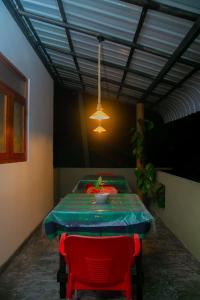a room with a table and two red chairs at Hill Top Heaven in Hikkaduwa
