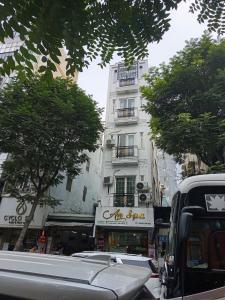 a white building on a city street with trees at Ann Home in Ho Chi Minh City