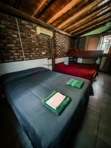 a bedroom with a large bed and a red chair at cabaña la olivia in Lunlunta