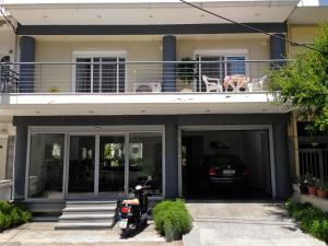 Una motocicleta estacionada frente a una casa con balcón en REM Apartments, en Tesalónica