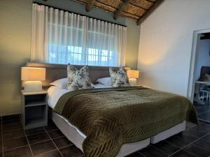Un dormitorio con una cama grande con ventana. en Gratitude Wellness Village - The Cottages, en Droëvlakte