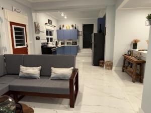 a living room with a couch and a kitchen at De' Seaside Escape in Wickhams
