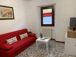 a living room with a red couch and a table at B&B Casa di Carla in Ripatransone
