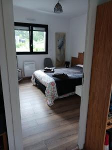 a bedroom with a bed and a wooden floor at chambre d'hôte proche mer in Yvias