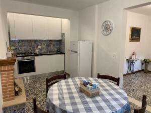 a kitchen with a table and a white refrigerator at B&B Casa di Carla in Ripatransone