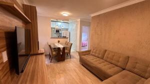 a living room with a couch and a dining room table at Apartamento Reformado - Pampulha in Belo Horizonte