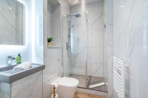 een witte badkamer met douche en toilet bij Penthouse Collection by EPIC in Liverpool