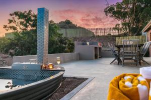 a patio with a tub and a table with a wine glass at Aardvark Bioreserve in Ladismith