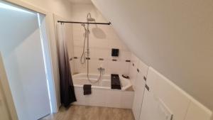 La salle de bains mansardée est pourvue d'une douche et d'une baignoire. dans l'établissement Ferienwohnung Richter, à Pirna 13 autres photos