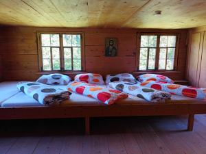 a large bed in a wooden room with windows at Ferienhütte See 4 in Seeberg